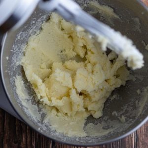 how to cream butter and sugar. Bowl of butter and sugar next to a hand mixer.