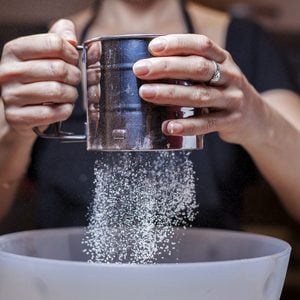 Sifting flour into a bowl/ Sifting flour